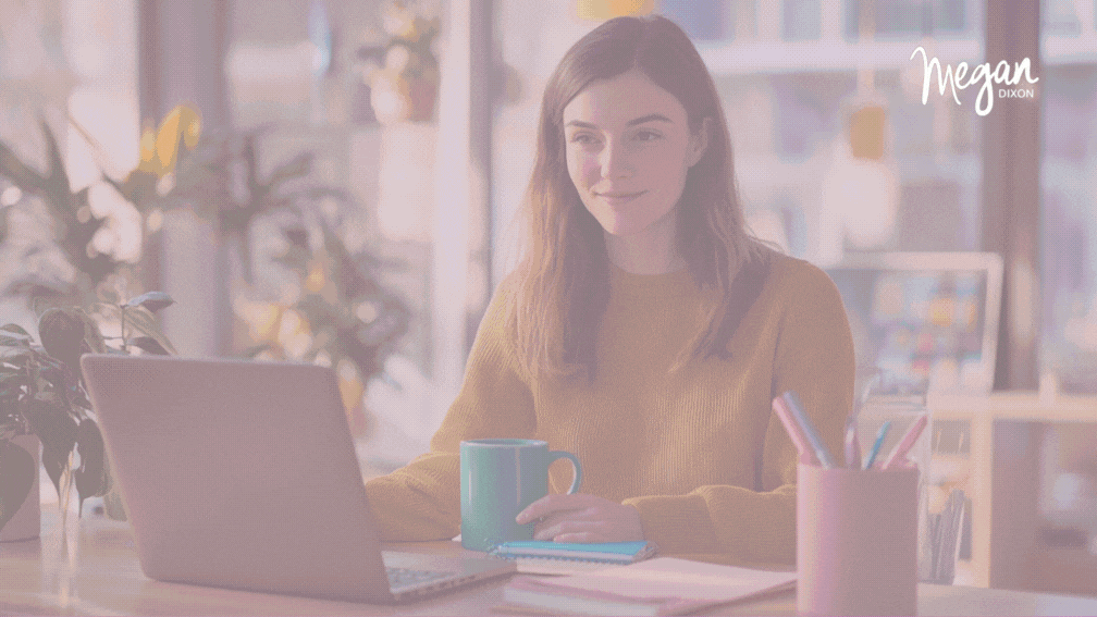Female entrepreneur using productivity app on laptop in coworking space with teal mug and modern decor.